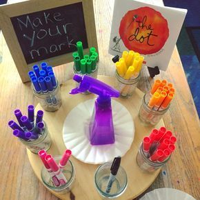 there are many different items on the table with markers and pens in glass cups,