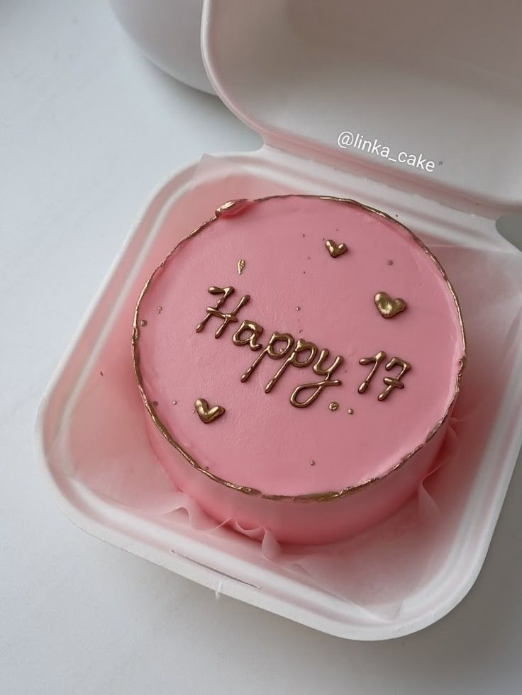 a pink birthday cake in a plastic container