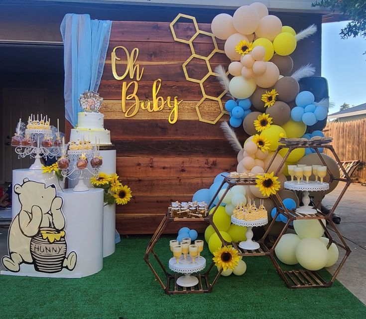 an outdoor baby shower with balloons, cake and sunflowers