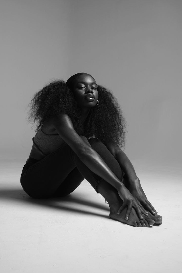 a woman sitting on the ground with her legs crossed