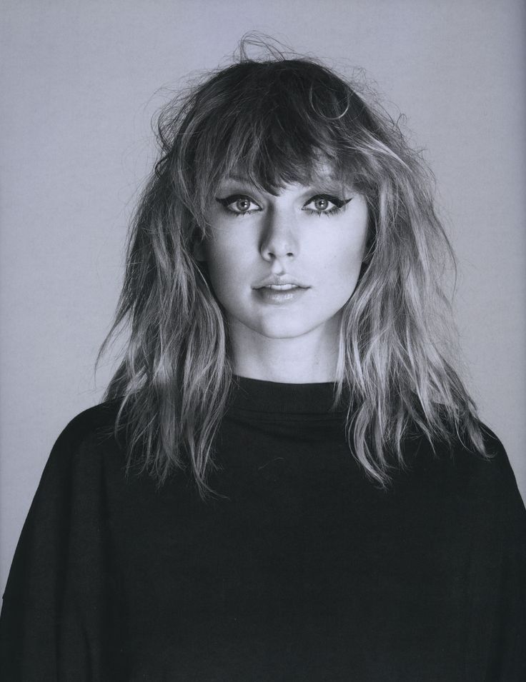 a black and white photo of a woman with long blonde hair wearing a black top