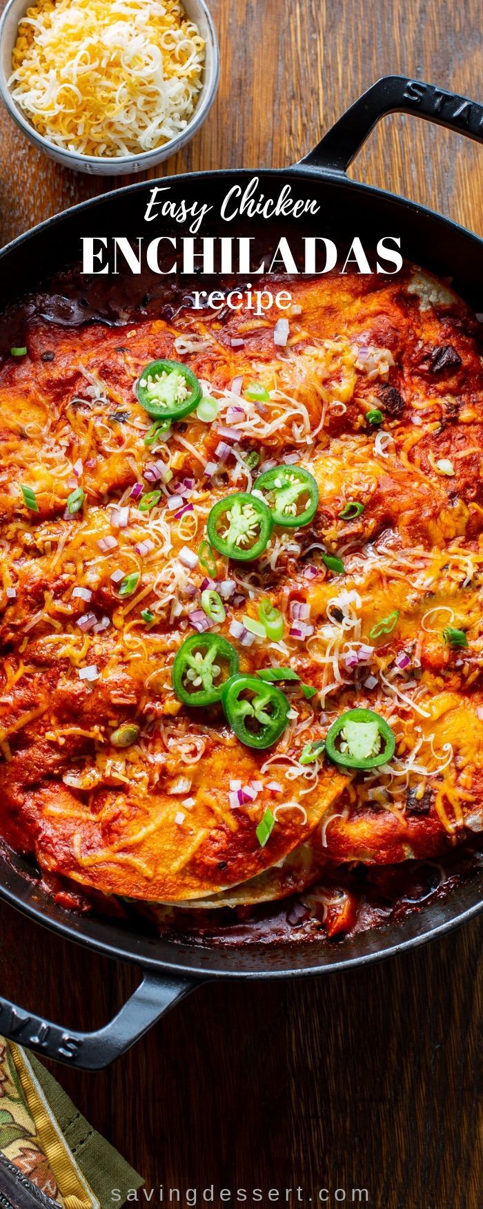 an enchiladas dish in a cast iron skillet on a wooden table