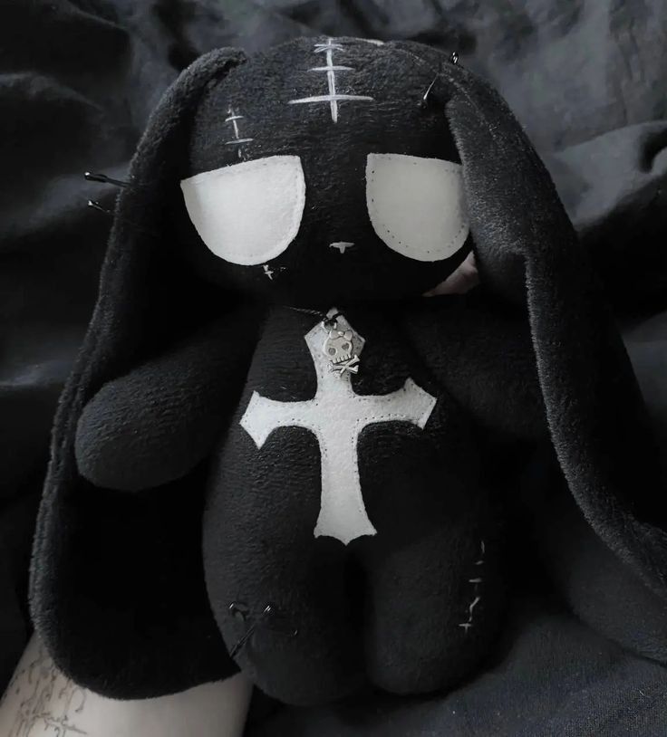 a black stuffed animal with white crosses on it's face