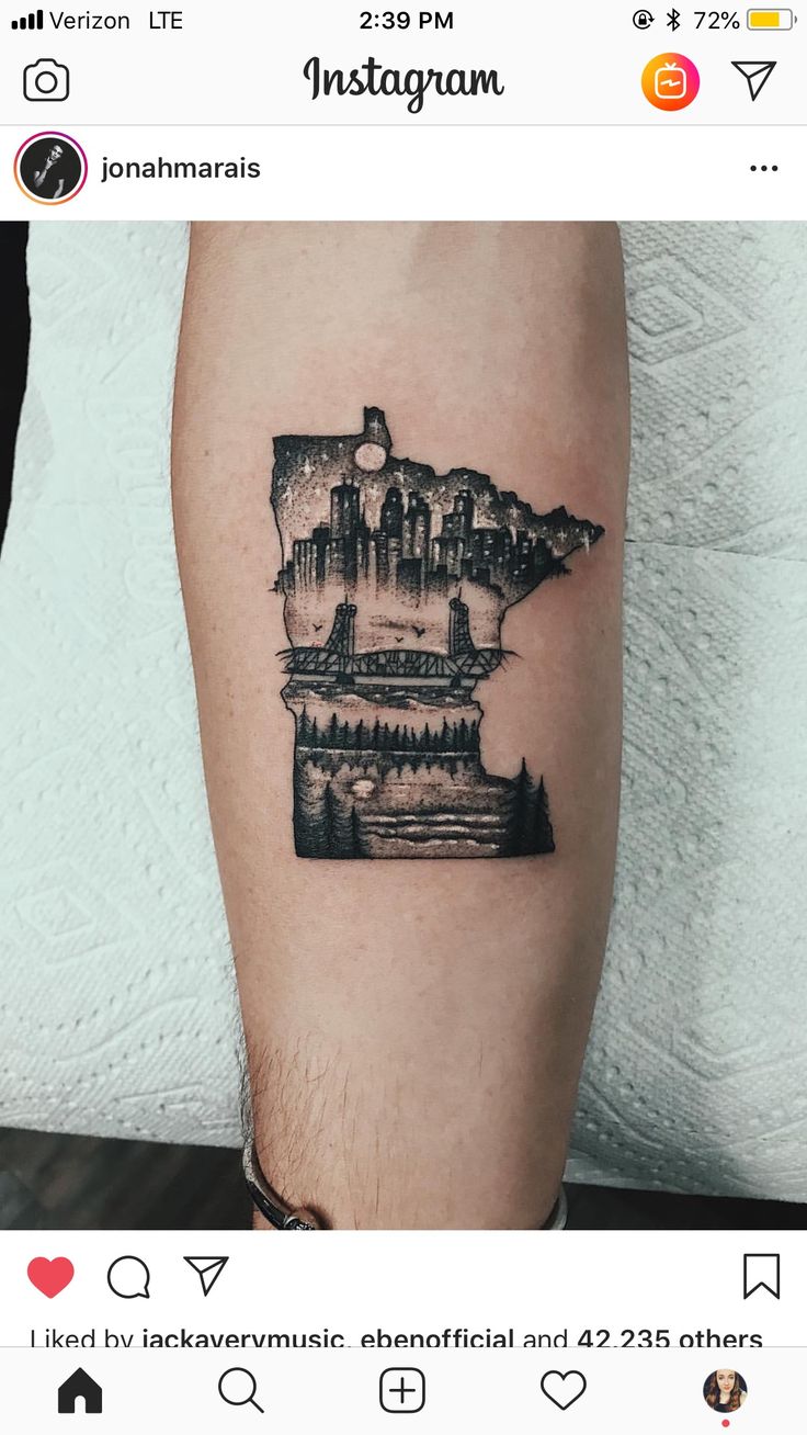 a man's arm with a black and white tattoo of a castle on it