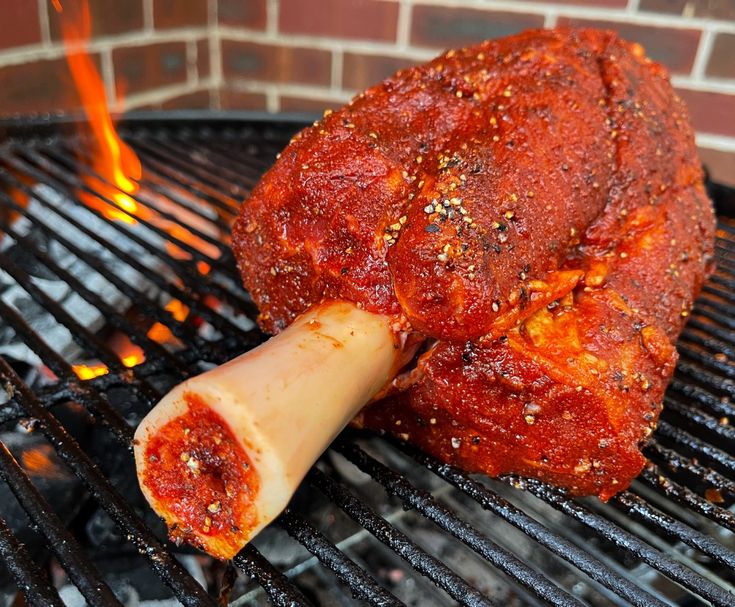 the meat is being grilled on the grill with a large piece of meat sticking out of it