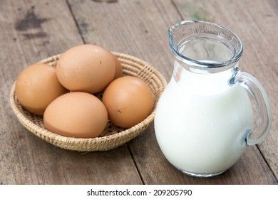 eggs in a basket next to a jug of milk