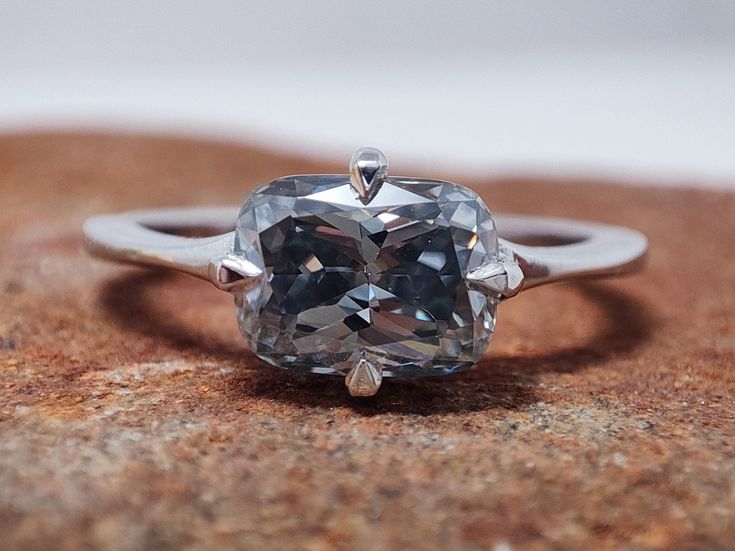 a diamond ring sitting on top of a rock