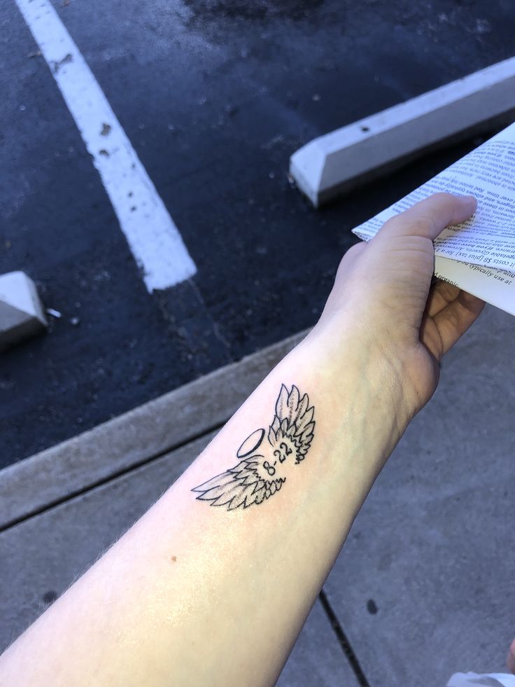 a person holding an open book with a bird on it's arm and the other hand