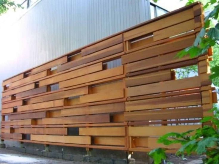 a building made out of wooden slats sitting on the side of a road next to trees