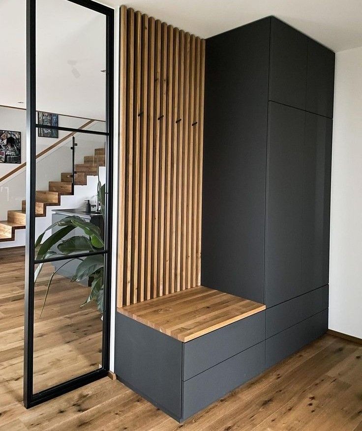 an empty room with wooden steps and black walls in front of a plant on the floor