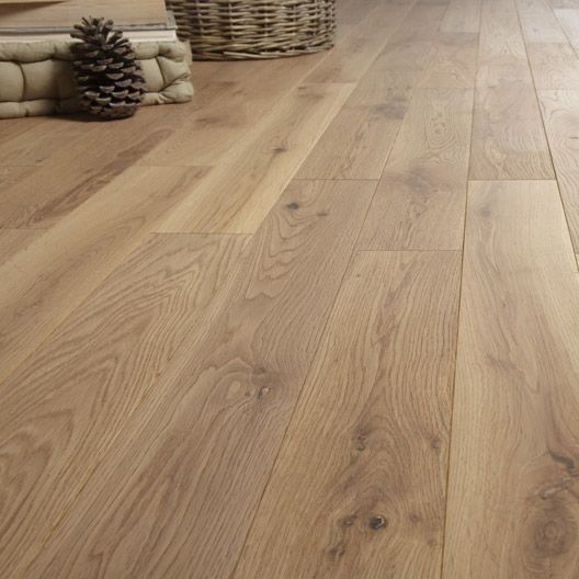 a wooden floor in a living room with pine cones on the floor and a basket next to it