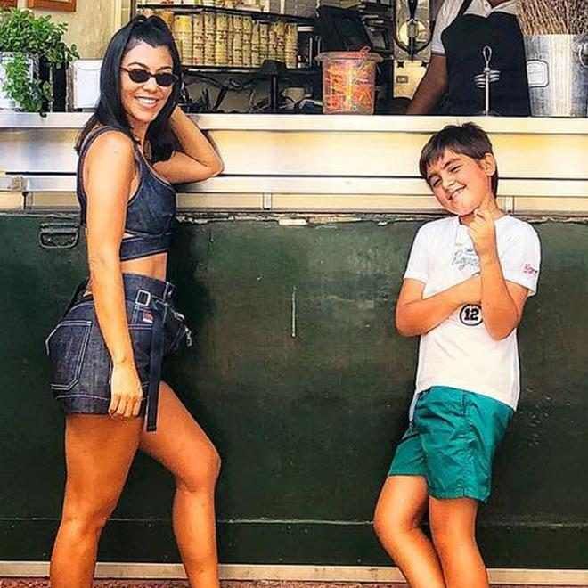 two young people standing next to each other near a food stand with an ice cream vendor in the background