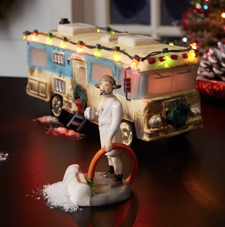 a small figurine is sitting on a table next to a camper trailer