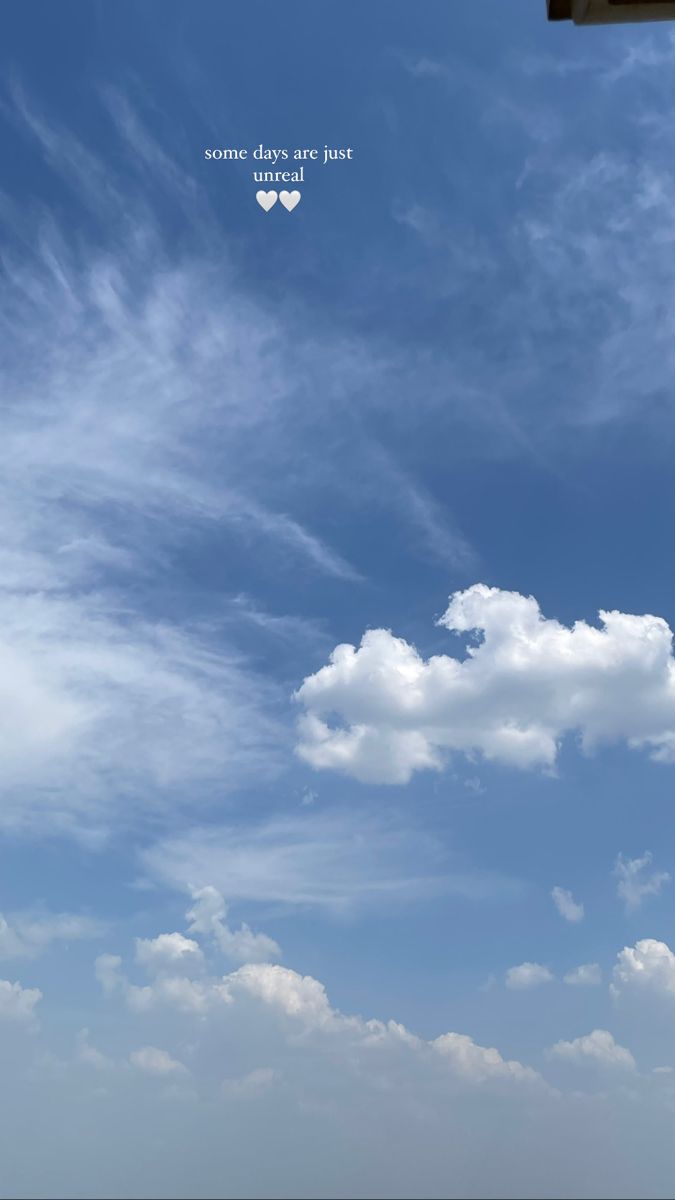 an airplane is flying high in the blue sky with some clouds above it and a stop light