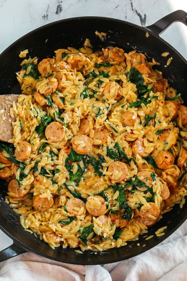 a skillet filled with pasta and sausage