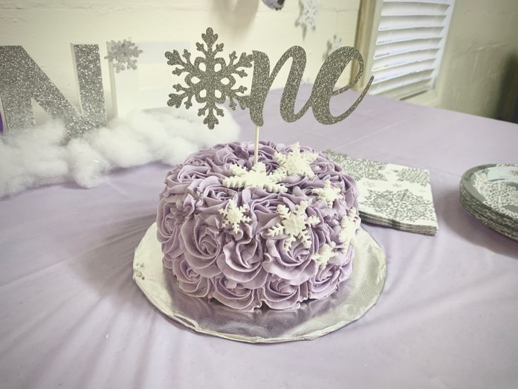 there is a cake on the table with snowflakes and frosting around it