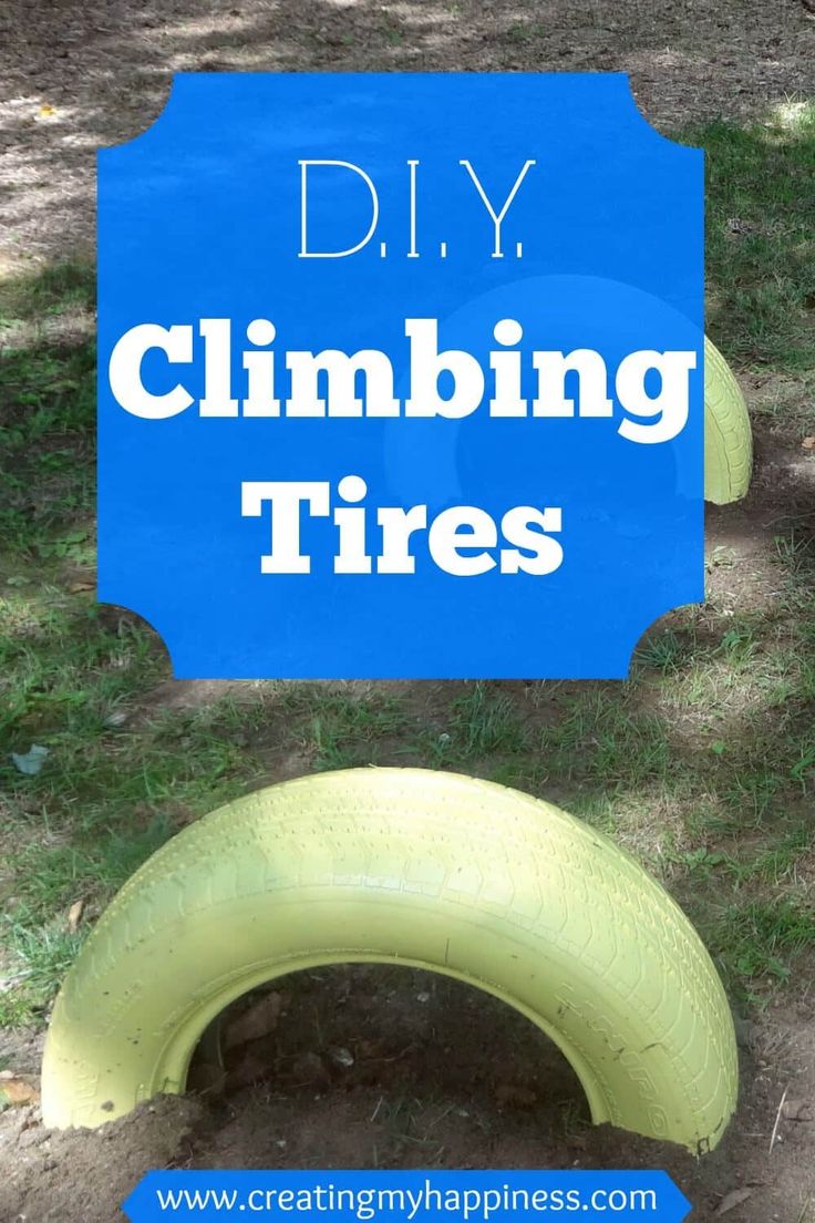 a blue sign that says diy, climbing tires in the dirt with grass and trees behind it