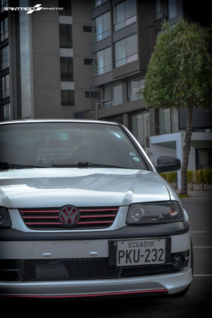 a white car parked in front of a tall building