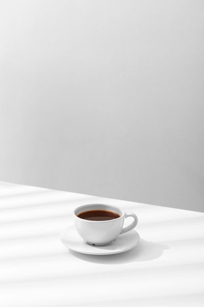 a cup of coffee sitting on top of a white table