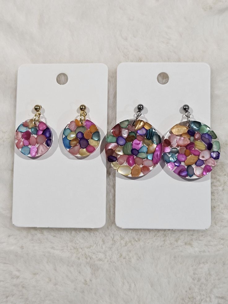 three pairs of earrings with colorful stones in the shape of circles on top of each other