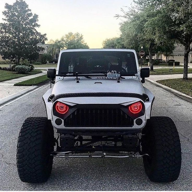 a white jeep parked on the side of a road