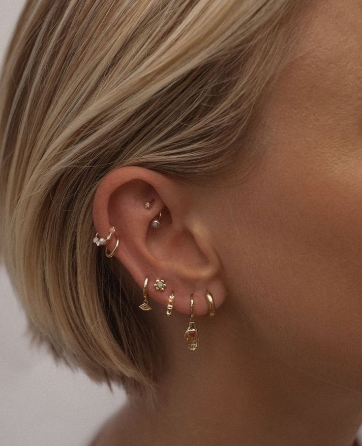 a close up of a person wearing ear piercings with small flowers on the side