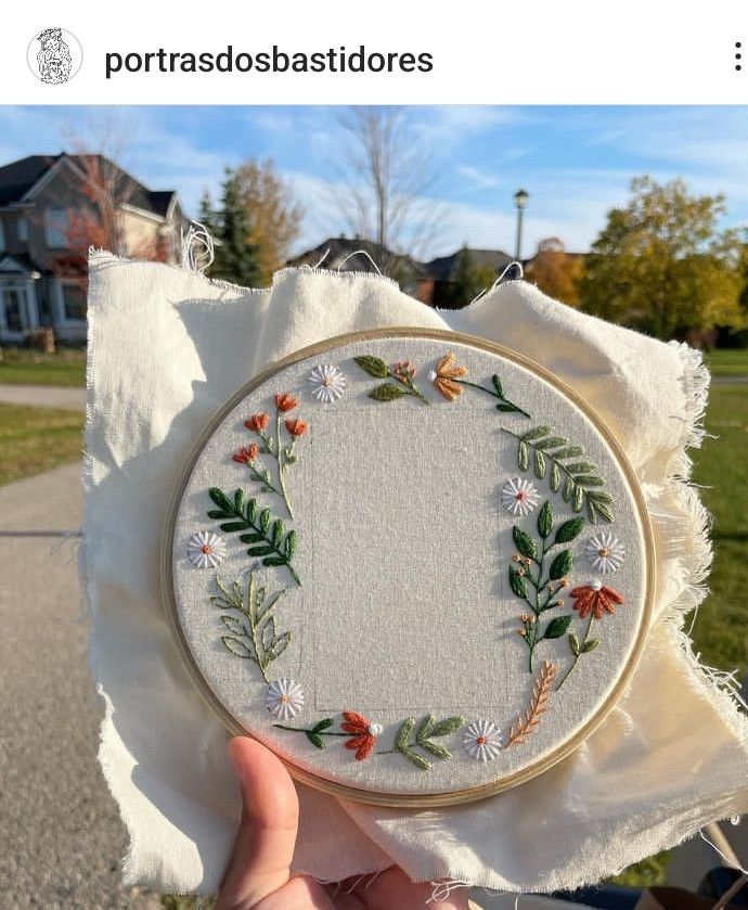 someone is holding up a small embroidery project