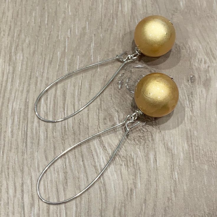 These handcrafted earrings are so pretty and unique!  18mm round glowing golden beads dangle from silver plated kidney hoops.  These earrings measure almost 2.75 inches in length.  Lightweight and FABULOUS Item is carefully packaged and shipped via USPS in a sturdy protective mailer. Check out more fabulous jewelry and enter my shop here: https://www.etsy.com/shop/jewelbytessyla View the positive feedback I've received from customers and check out some beautiful art prints for nursery and home a Handmade Gold Wrap Earrings For Party, Yellow Ear Wire Party Earrings, Teardrop Earrings Gift, Elegant Nickel-free Beaded Earrings For Festive Occasions, Elegant Festive Beaded Earrings Nickel Free, Elegant Festive Nickel-free Beaded Earrings, Gold Teardrop Earrings With Round Beads For Gifts, Handmade Sterling Silver Clip-on Earrings For Party, Gold Beaded Sterling Silver Earrings For Gift