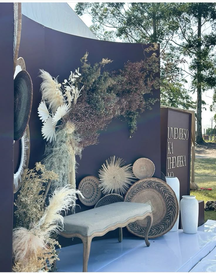 a bench sitting next to a wall covered in flowers and plants on it's side