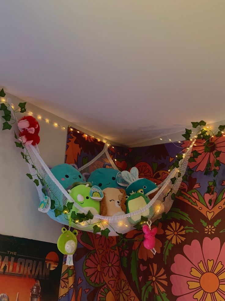 there is a hammock with stuffed animals in it and lights on the ceiling