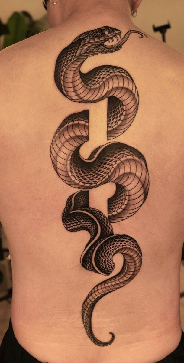 a woman's back with a snake tattoo on it