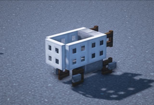 a small white building sitting on top of a cement ground next to a shadow cast object