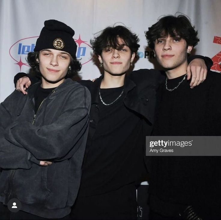 three young men posing for the camera at an event