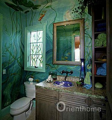 a bathroom decorated in green and blue with fish painted on the walls, along with a toilet