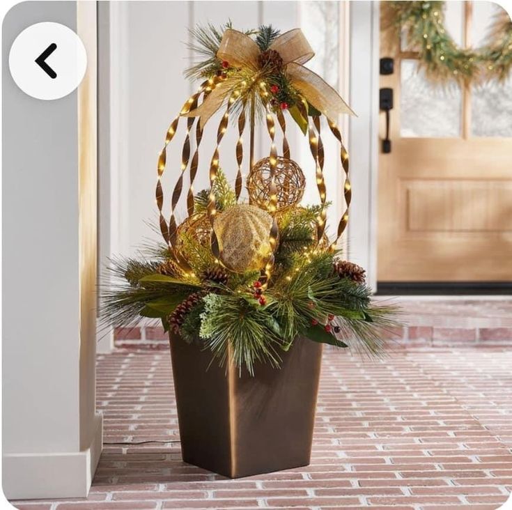 a potted plant with christmas decorations on the top and in front of a door