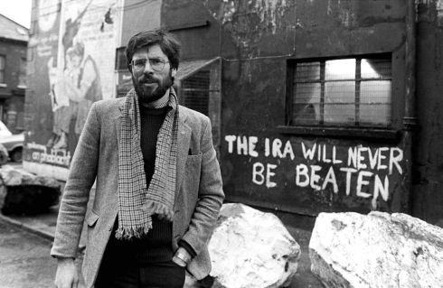 a man standing in front of a building with graffiti on it