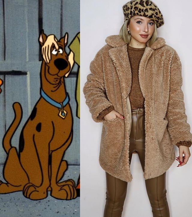 a woman standing next to a cartoon dog wearing a leopard print hat and brown pants