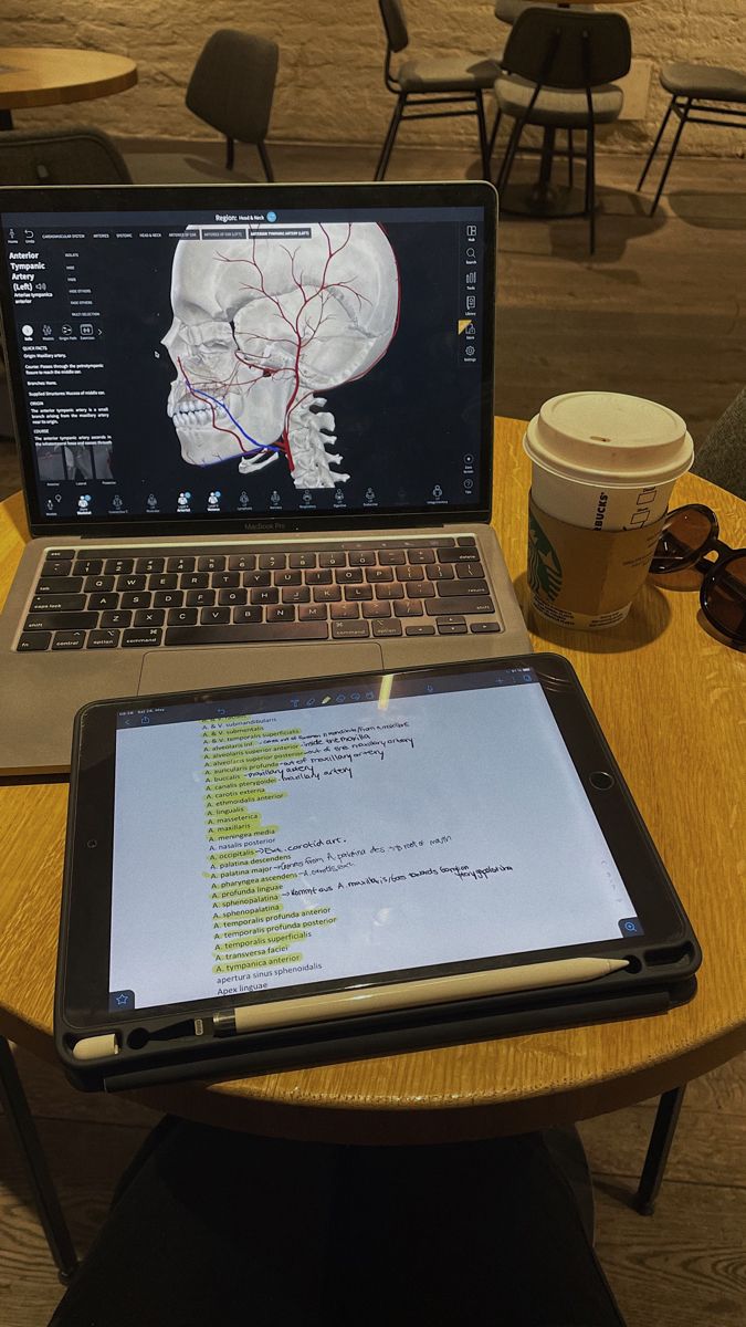 an open laptop computer sitting on top of a wooden table next to a cup of coffee