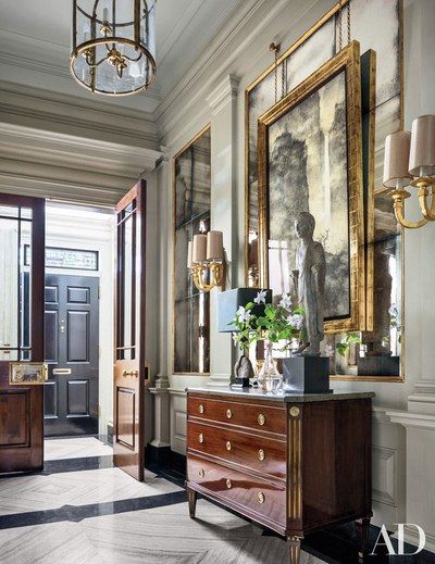 a room with two paintings on the wall and an antique dresser in front of it