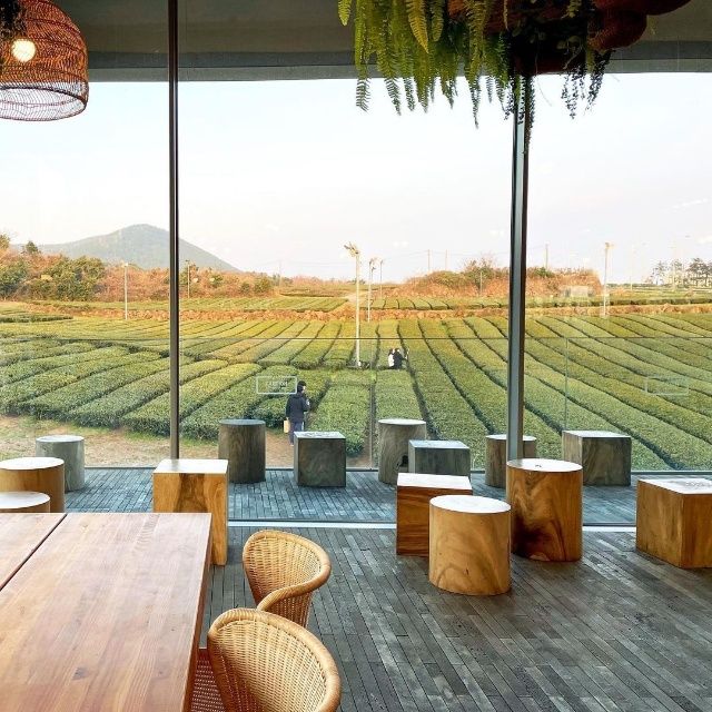 a wooden table sitting on top of a hard wood floor next to a large window