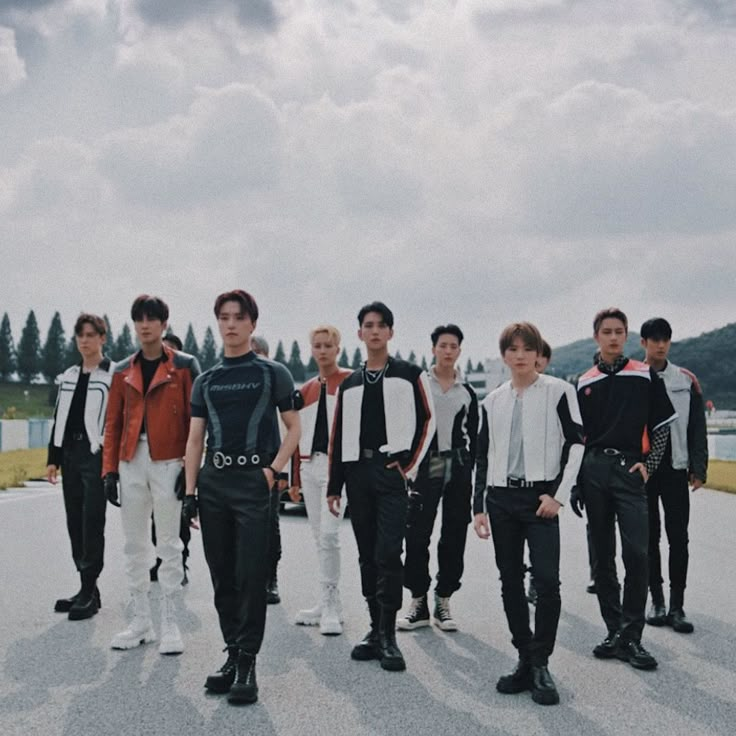 a group of young men standing next to each other on top of a tarmac