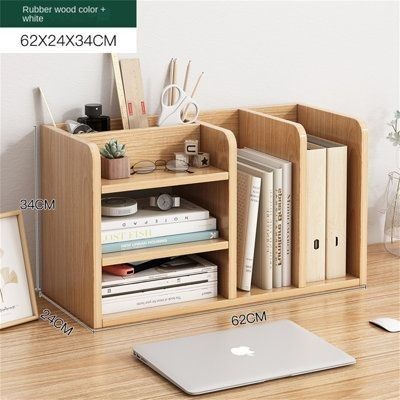 an apple laptop is sitting on a desk next to a wooden shelf with books and other items