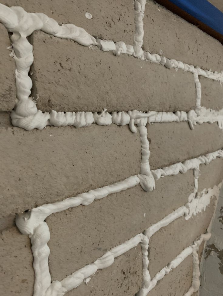 a brick wall with white paint on it