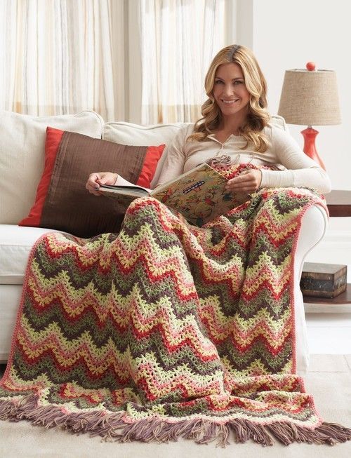 a woman sitting on a couch holding a book