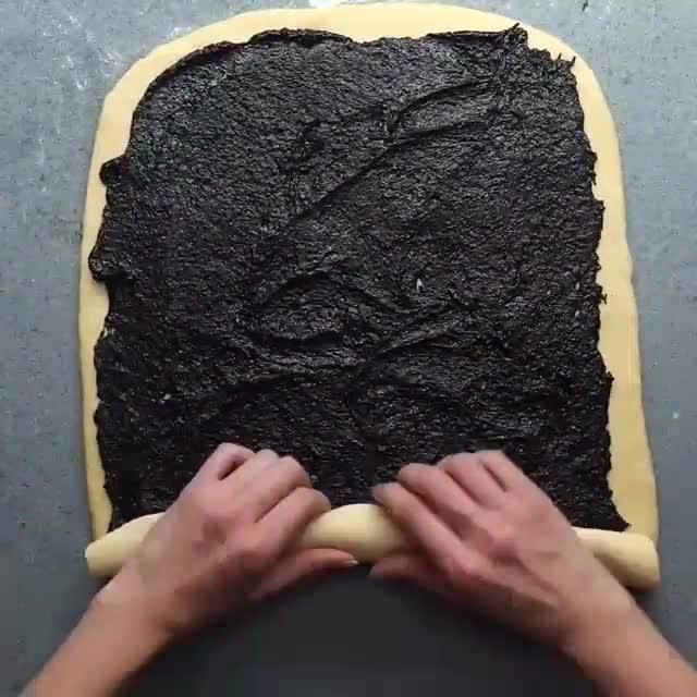 a person rolling out dough on top of a cookie sheet in the shape of a square