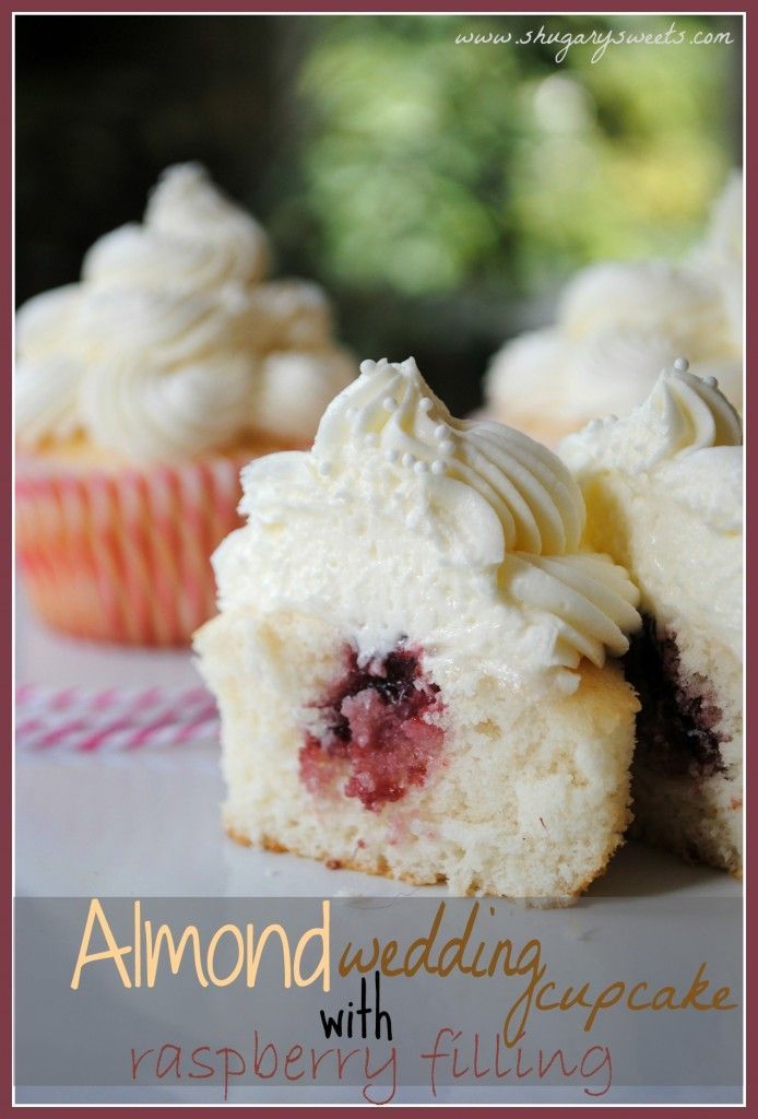 some cupcakes with white frosting and raspberry filling