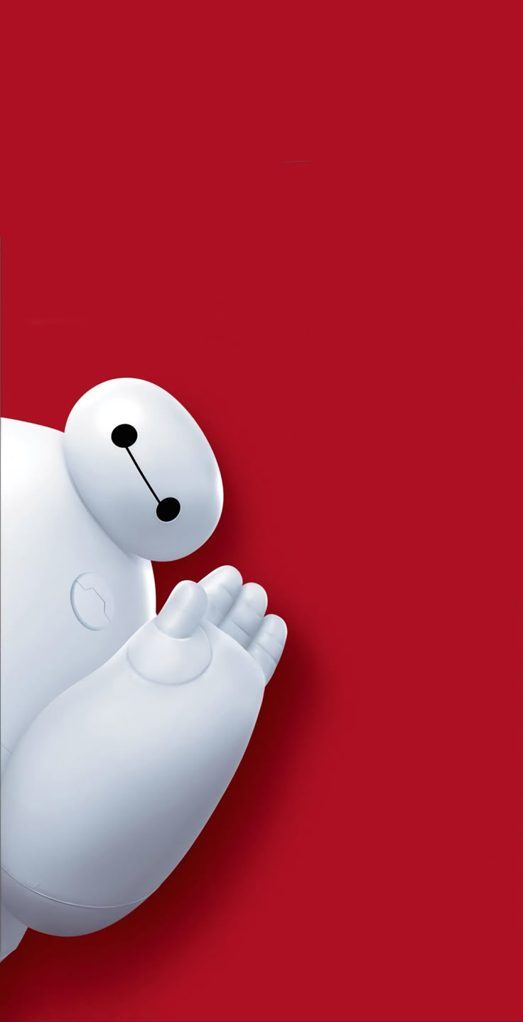 a white teddy bear is standing in front of a red wall and holding its paw up