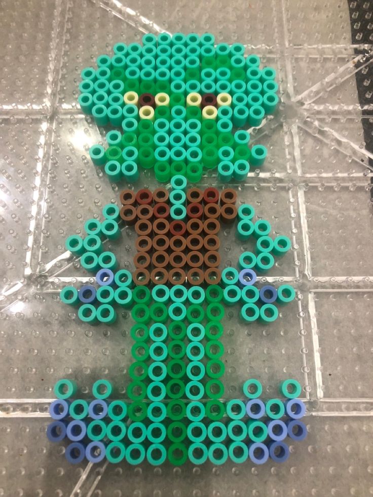 an image of a green man made out of legos on the floor with circles around it