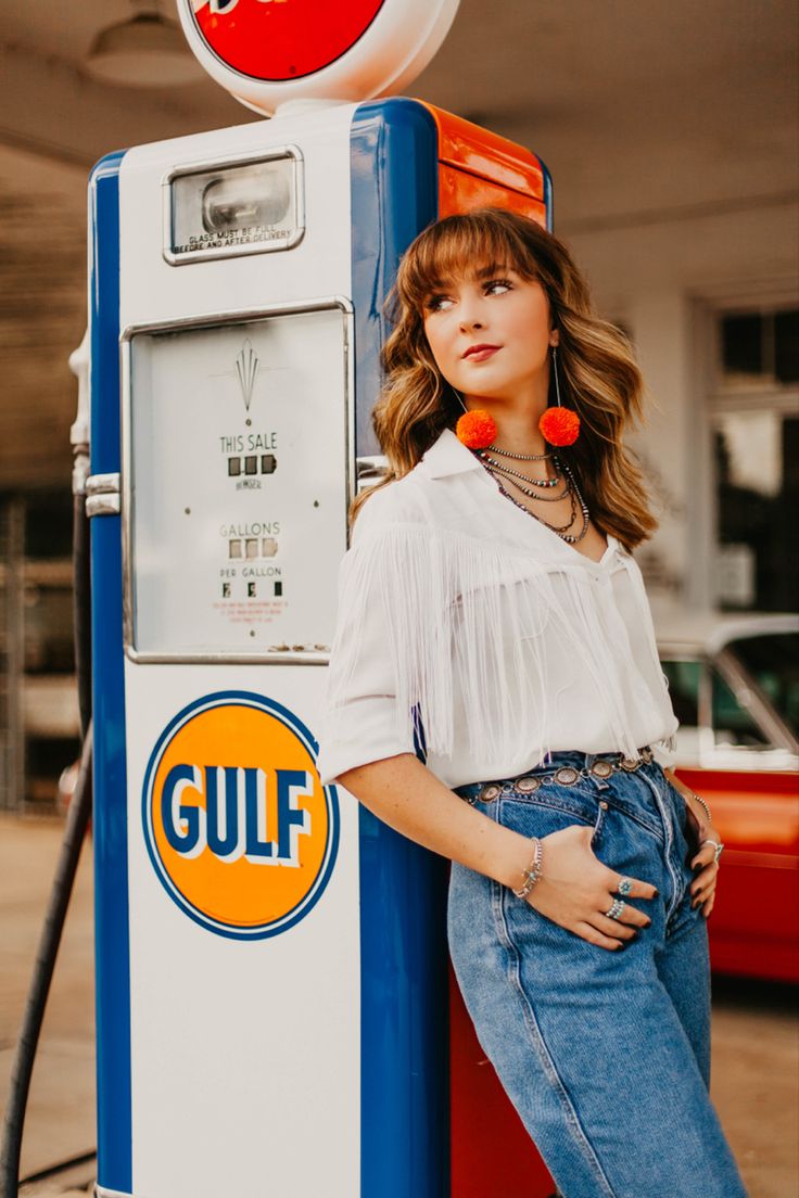 a woman standing next to a gas pump