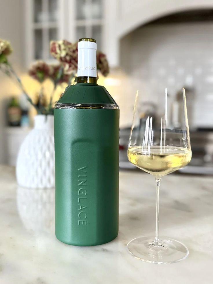 a bottle of wine next to a glass on a counter